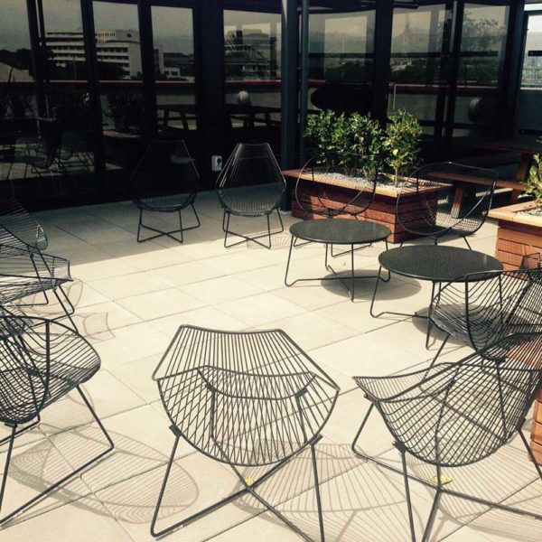 Black wire chairs, Piha Loungers & Oneroa outdoor coffee tables sit on rooftop garden
