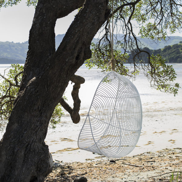 Outdoor furniture, Handcrafted wire hanging chair hanging in a tree.