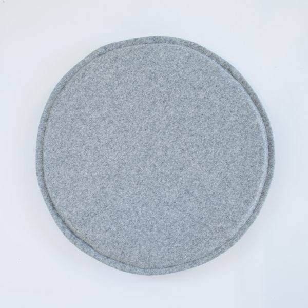 A grey, felted wool, round circle chair or stool pad / cushion