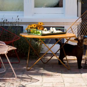 Outdoor furniture setting with mid century inspired wire chairs, table, side table.
