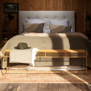 Benmore wire bench styled at the end of a bed with a throw and a hat.