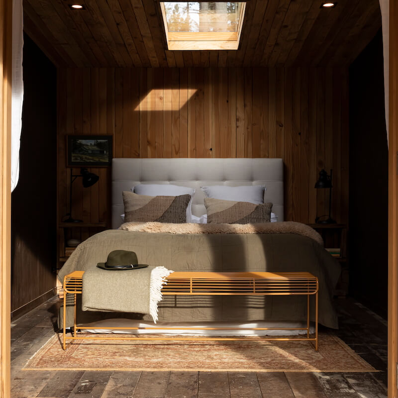 Benmore wire bench styled at the end of a bed with a throw and a hat.